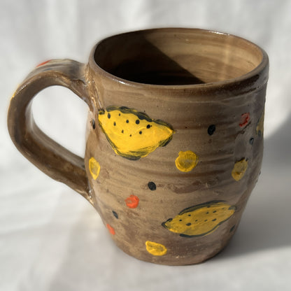 Brown Ceramic mug with lemon designs on a white background