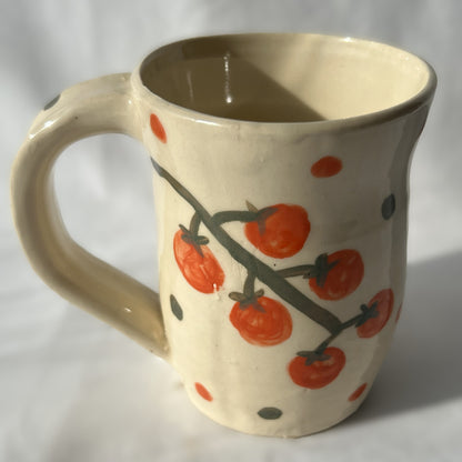 Ceramic mug with tomato design on a white background