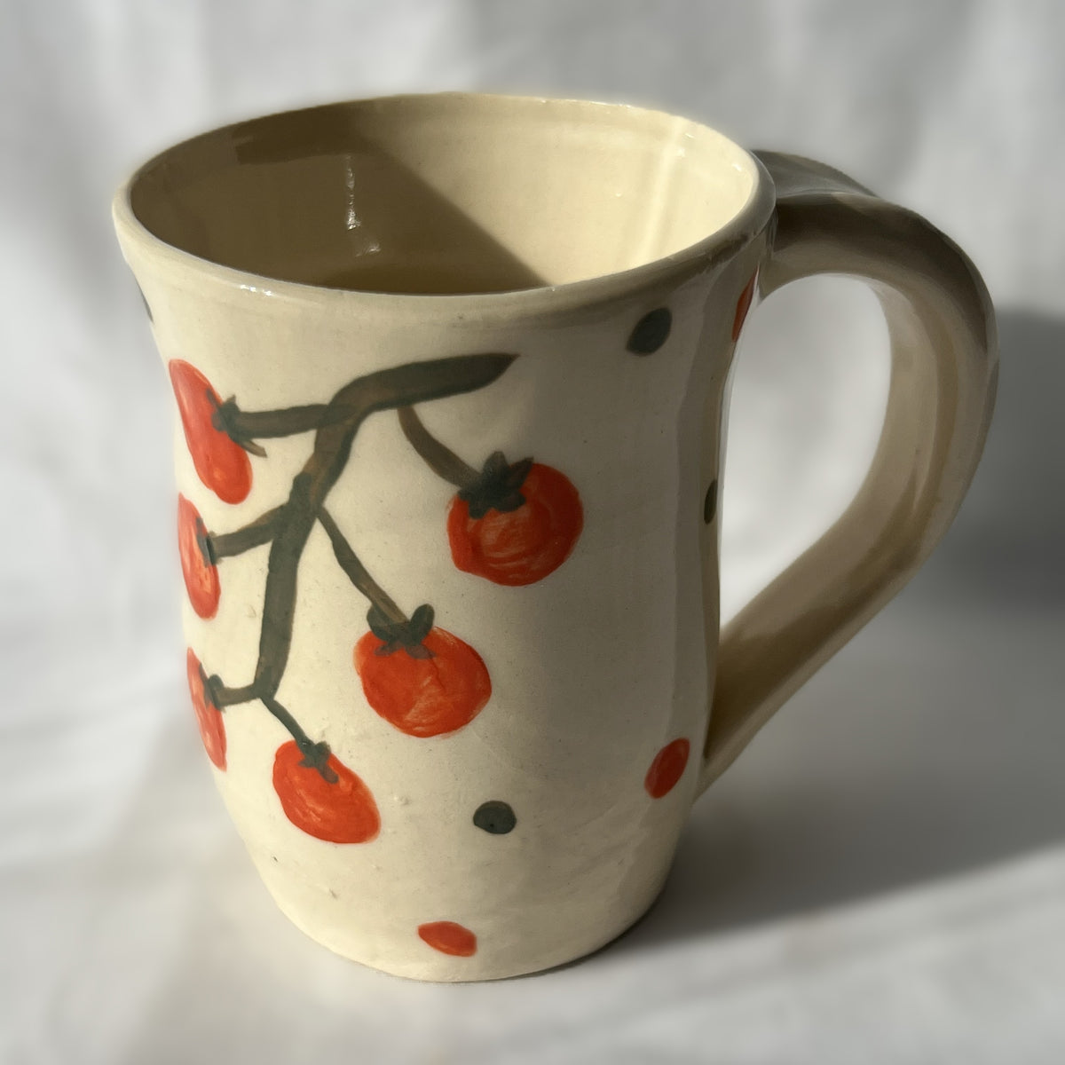 Ceramic mug with tomato design on a white background