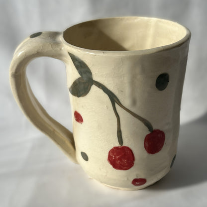 Ceramic mug with cherry design on a plain background