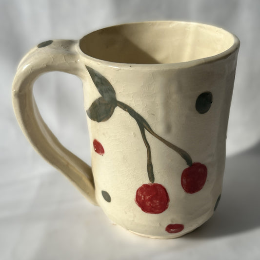 Ceramic mug with cherry design on a plain background
