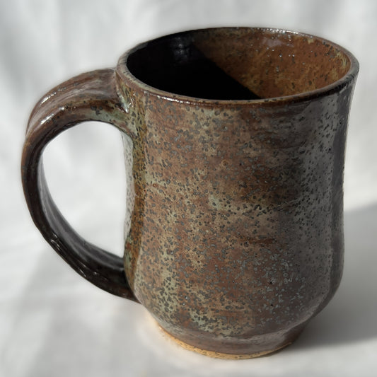 Brown ceramic mug with speckled texture on a white background