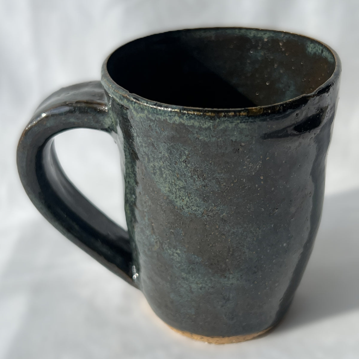 smooth slightly speckled texture dark green and black ceramic mug