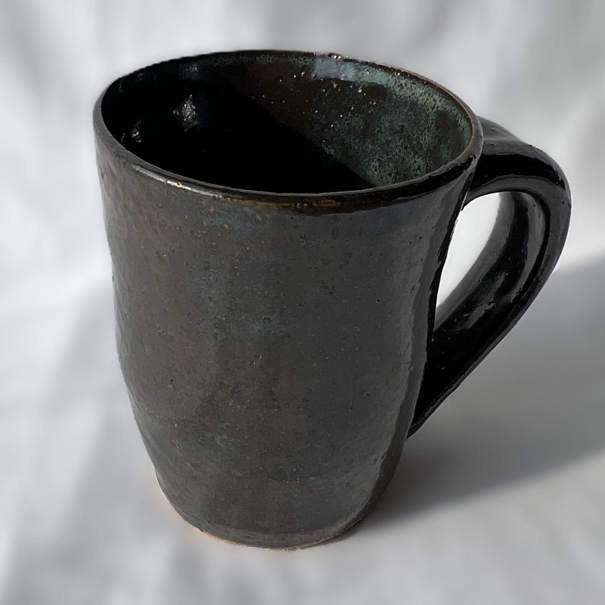 smooth and slightly textured speckled black and dark green ceramic mug