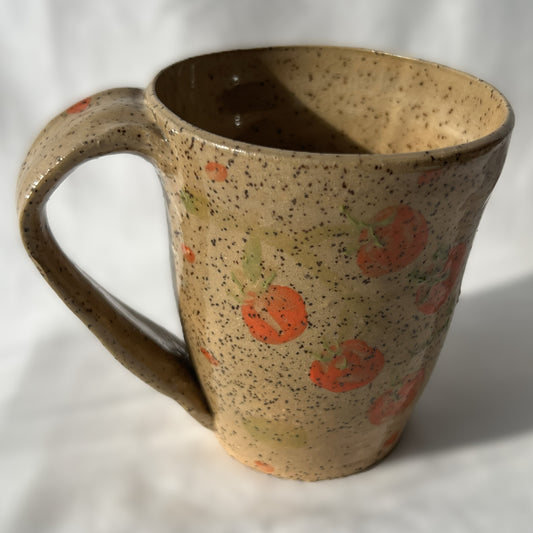 speckled Ceramic mug with tomato design on a tan background