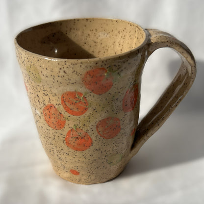 speckled Ceramic mug with tomato design on a tan background