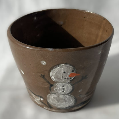Brown ceramic cup with a snowman design