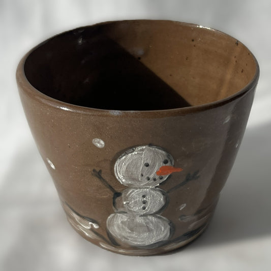 Brown ceramic cup with a snowman design