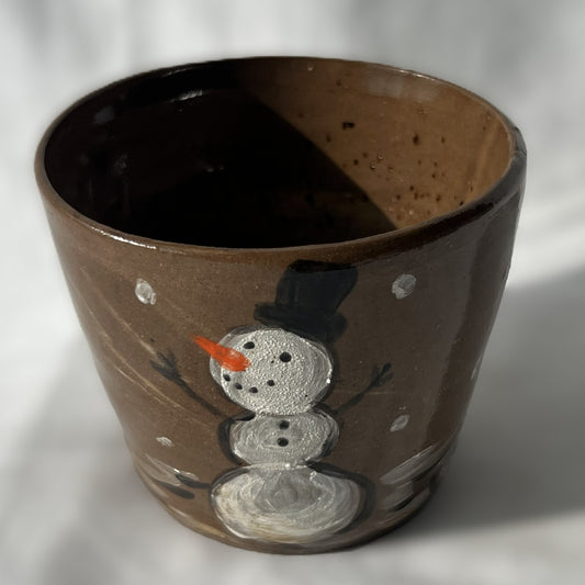 Brown ceramic cup with a snowman design