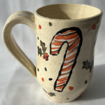 Ceramic mug with a candy cane design on a plain background