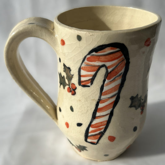Ceramic mug with a candy cane design on a plain background
