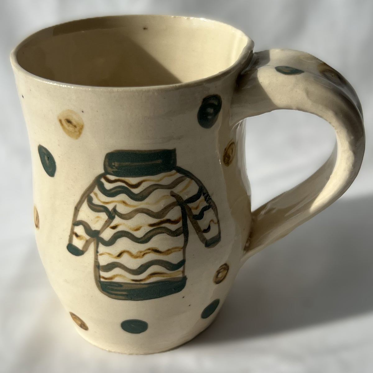 Ceramic mug with a sweater design on a white background