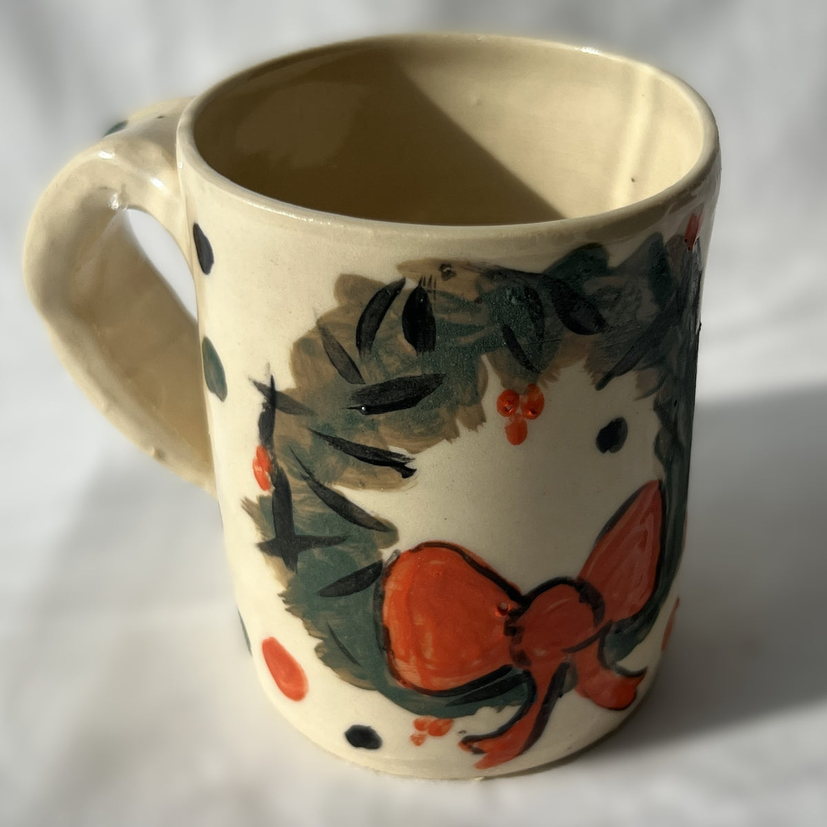 Ceramic mug with wreath design on a White background