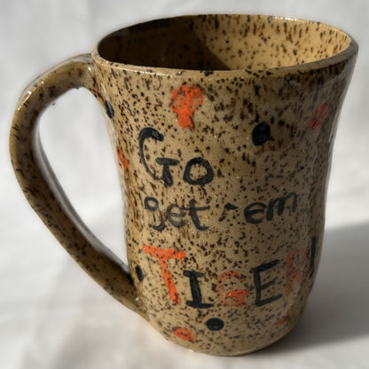Speckled ceramic mug with 'Go get 'em TIGER!' text on a brown background