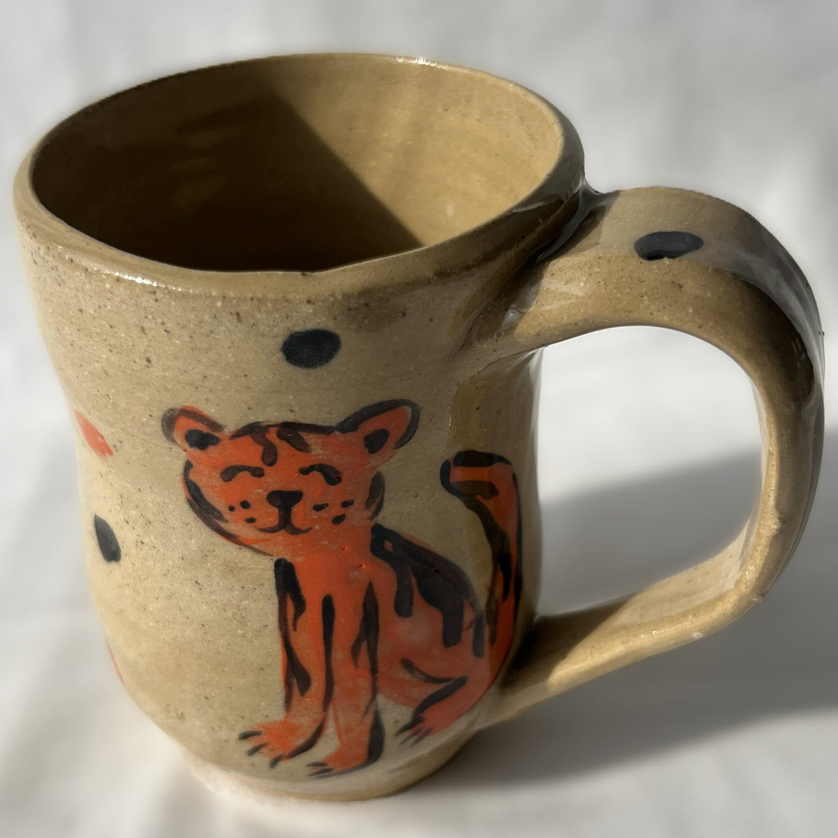 Ceramic mug with a tiger design on a Tan background