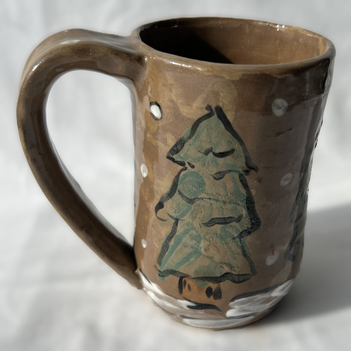 Ceramic mug with a tree design on a brown background