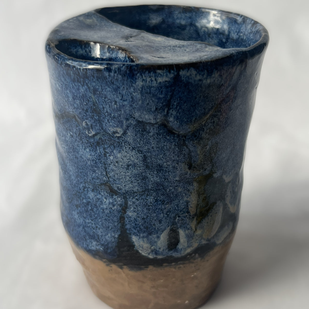 Blue and Brown Handle less ceramic tumbler with a partial lid