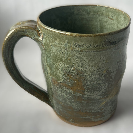 Ceramic Mug with a varied light green glaze that goes tan in some areas 
