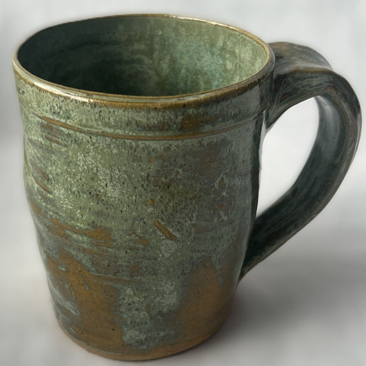 Ceramic Mug with a varied light green glaze that goes tan in some areas 