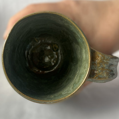 Ceramic Mug with a varied light green glaze that goes tan in some areas 